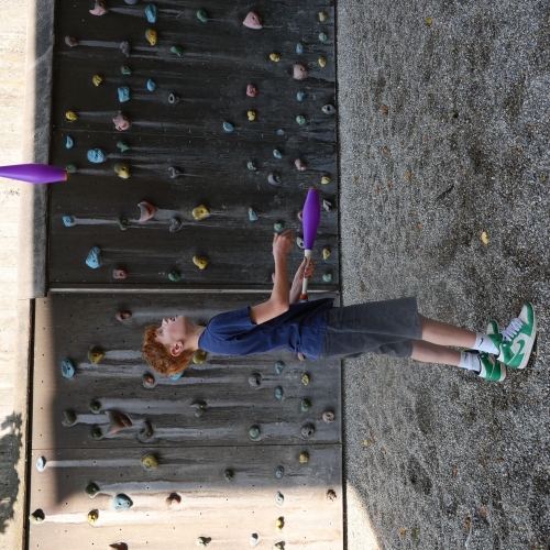 Ein Junge jongliert mit Keulen