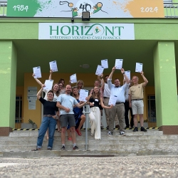 Gruppenbild vor einem Gebäude mit Horizontschriftzug