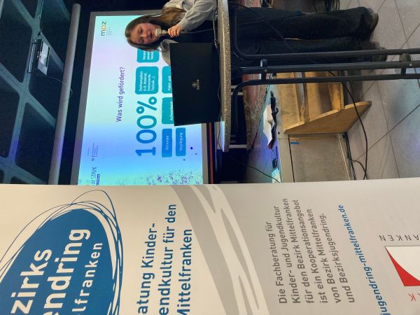 Eine Vortragende vor der Powerpointpräsentation