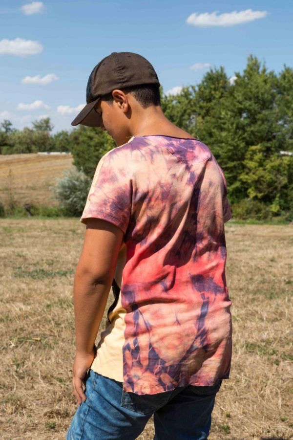 Ein Junge steht auf einem Feld und trägt ein selber hergestelltes T-Shirt